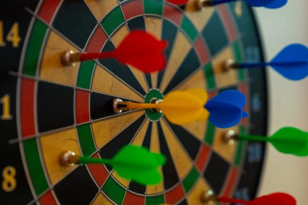 A close-up of vibrant colored darts on a dartboard, representing focus and precision in sports.